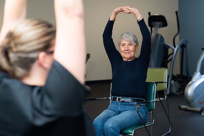 Therapist leads exercise session with sitting patients