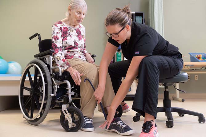 Nurse assists woman in wheelchair