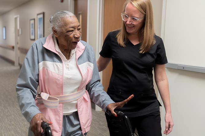 care home resident grips bar during physical therapy session